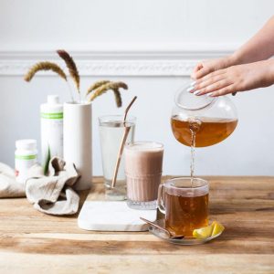 herbalife nutrition gesundes frühstück und eine hand die ein teegetränk eingiesst