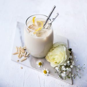 Glass of vanilla almond protein shake on a marble table